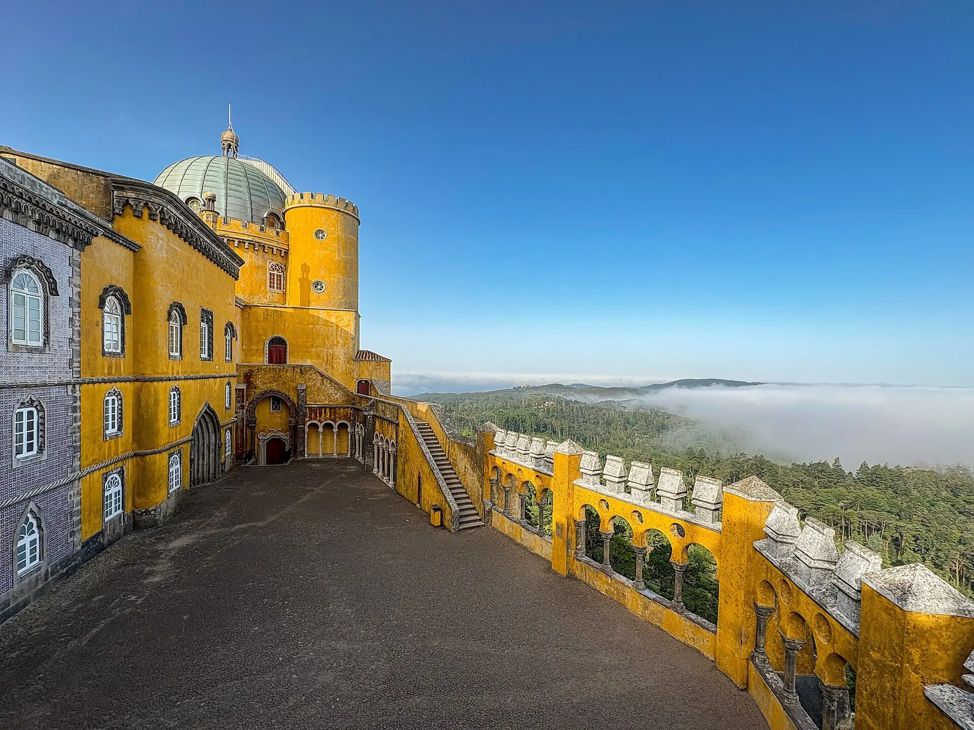 Early morning at the Pena Palace with mist over the forest below