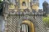 Visitors, one in a wheelchair, at the gateway into the Pena Palace