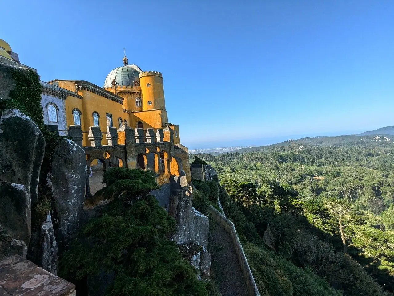 View from a Pena terrace over the yellow walls and the forested hills of Sintra
