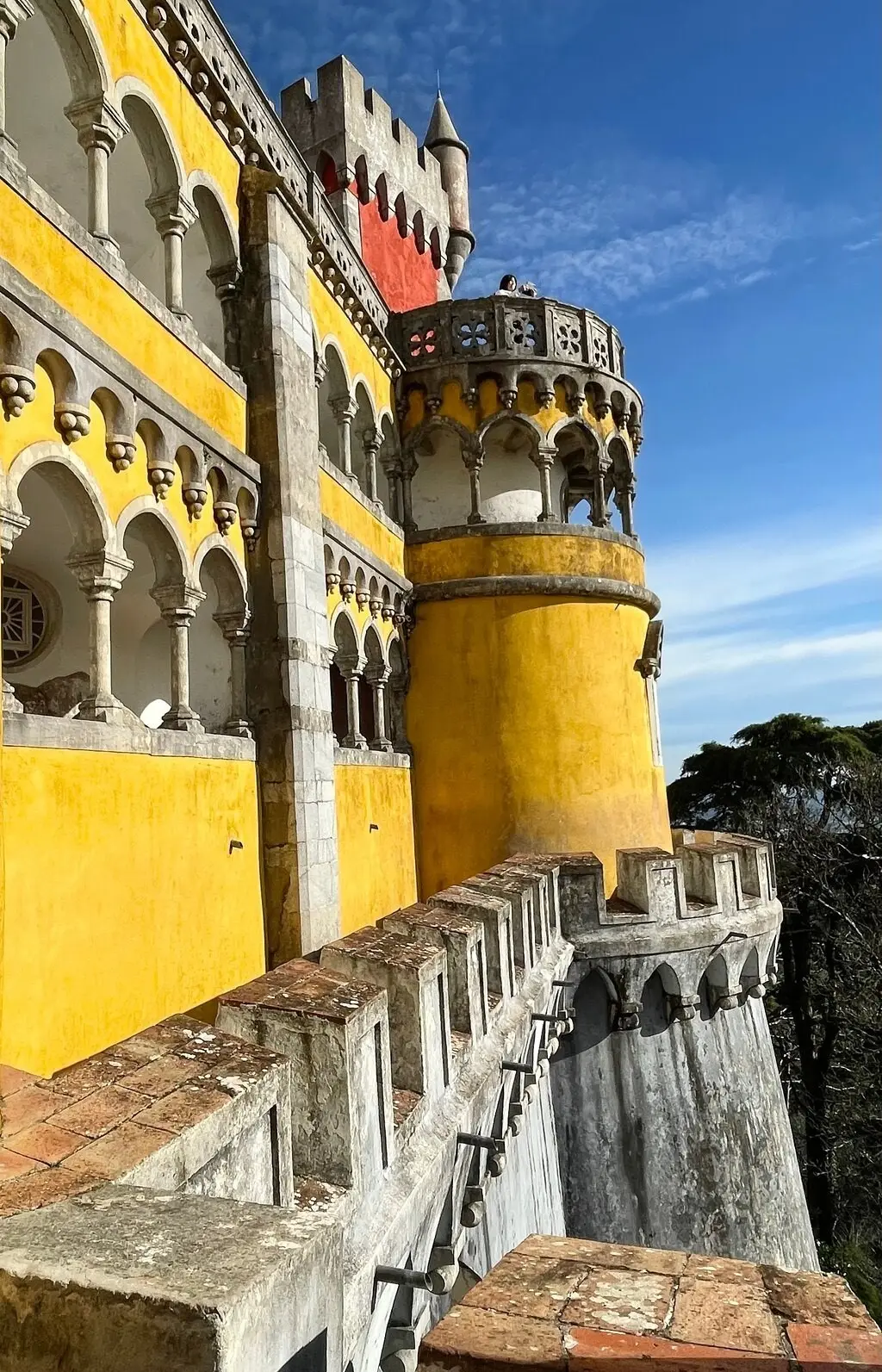 The yellow arcade and round tower on the Pena terraces under a blue sky